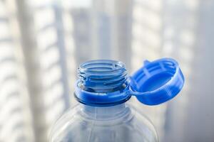 Close-up of innovative plastic bottle with attached blue cap for sustainable packaging, sunlight photo