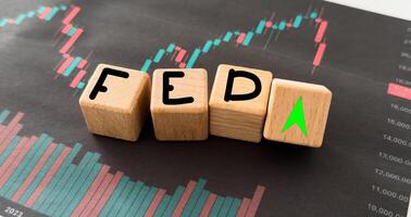 FED wording with up and down arrow on USD dollar banknote for Federal reserve increase and decrease interest rate control which effect to America and world economic growth concept. photo