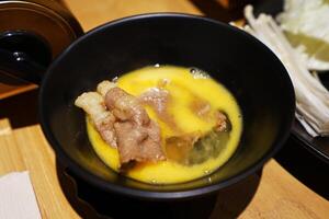 Close up Sliced Wagyu beef and pork, raw egg and dipping sauce- Sukiyaki Japanese hot pot photo