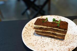 Close up dish of Tiramisu- Italian dessert made of Mascarpone custard layered with whipped cream, rum and coffee soaked ladyfingers photo
