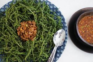 Battered and deep fried Acacia Pennata leaf or Climbing Wattle vegetable served with stir fry minced pork with chili photo
