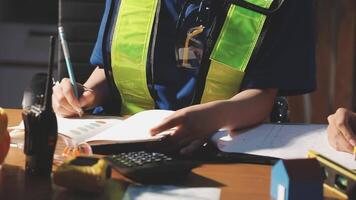 Two people sitting at a table with a calculator and paper video