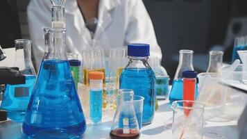 A person in a lab coat is looking at a bunch of blue and red liquid video