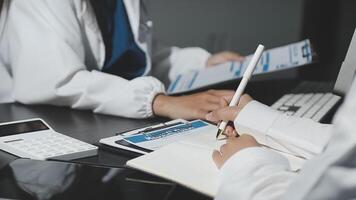 A doctor writing on a notepad while another person looks at the paper video