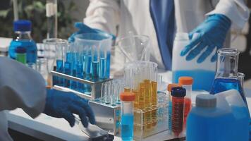 Laboratory workers in lab coats and gloves working with test tubes video