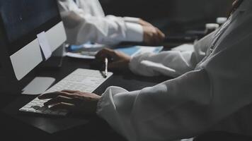 Two people in lab coats working on computers video