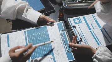 A group of doctors and nurses are working on a clipboard video