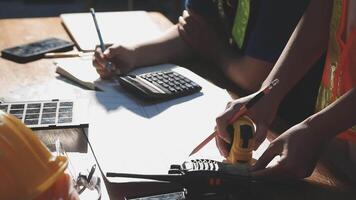A person working on a construction project with a calculator and a hard hat video