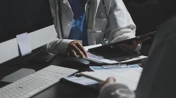 en läkare är arbetssätt på en dator medan annan person utseende på honom video