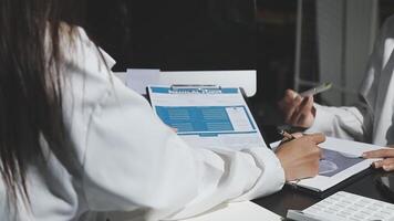 Two people in lab coats sitting at a desk video
