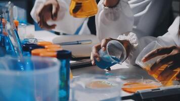 People in lab coats working with colorful liquids video