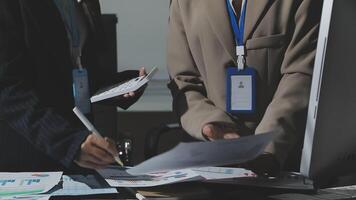 Two people in business attire are working on paperwork video