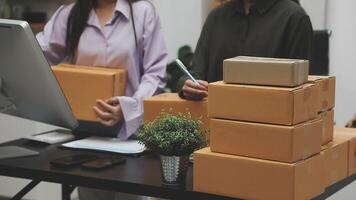 Two women are working on a computer and a stack of boxes video