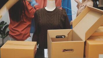 A woman is standing next to boxes and a mannequin video