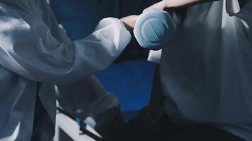 A person in a white coat is holding a blue object video