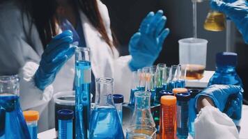 A group of people in lab coats and gloves are working on a table video
