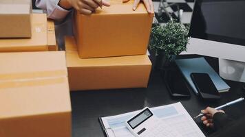 A man is holding a box and a calculator on a desk video