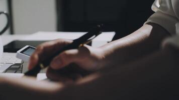 A person writing on a piece of paper while sitting at a desk video