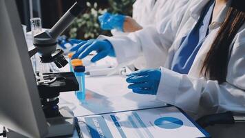 A woman in lab coat and gloves is working on a computer video