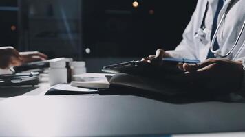 A doctor is using a tablet while sitting at a desk video