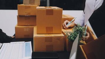 A man and woman are working on a computer and a box video