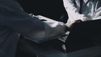 Two doctors working on a laptop in the dark video
