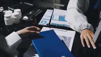 A person is holding a blue folder in front of a computer video