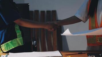 Two people shaking hands at a desk with papers video