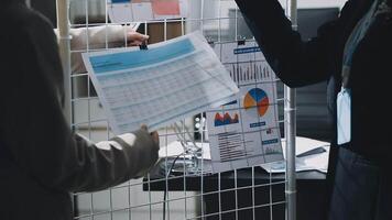 Two people looking at a document on a table video