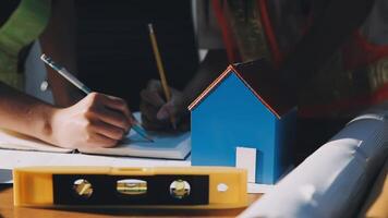 A person is working on a house with a pencil and a ruler video
