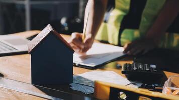 A person is working on a house model on a desk video