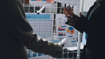 dois pessoas falando dentro frente do uma parede com gráficos e gráficos video