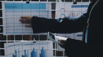 A person in a suit is looking at a screen with graphs video