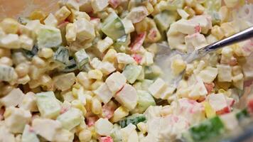 Salad ingredients combining surimi, cucumber, corn, egg with creamy mayonnaise, creating smooth seafood appetizer blend. Top view of creamy salad preparation with surimi, cucumber, corn, and egg video