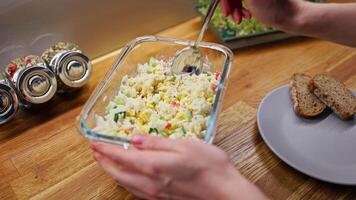 Culinary professional preparing gourmet crab salad with fresh corn, cucumber, and mayonnaise, served alongside crisp rye bread slices on rustic wooden surface. Chef crafting delicate crab salad video