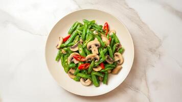 Indonesian Tumis Buncis Jamur with green beans, mushrooms, and red chili on marble table photo