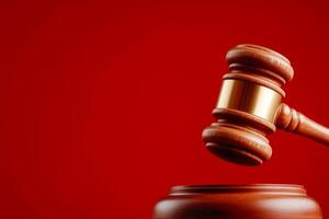 Wooden judge gavel with striking block on red background symbolizing justice and authority photo