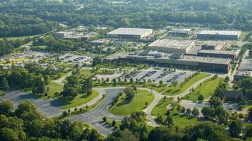 Aerial view of a commercial area with buildings and parking lots surrounded by greenery photo