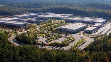 Aerial view of a modern industrial complex surrounded by trees and parking areas photo