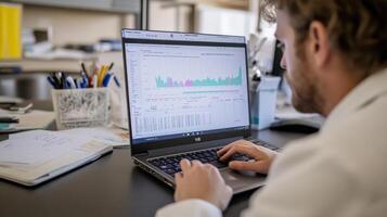 A person analyzes data on a laptop in a professional workspace photo