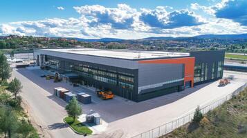A modern industrial building with loading area and vehicles under a blue sky photo