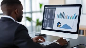 A professional analyzing data on a computer screen in an office setting photo