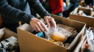 A person organizing items in a cardboard box, possibly for donation or sorting photo