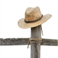 A straw hat resting on a wooden fence post, symbolizing rural life and leisure photo