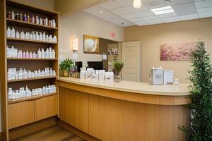 A serene reception area with shelves of skincare products and a welcoming counter photo