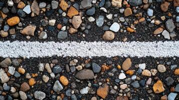 Close-up of a gravel surface with a white line, showcasing textures and colors of stones photo