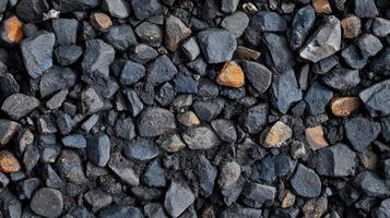 A close-up view of various sizes of dark gravel and stones, showcasing texture and color photo