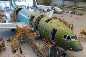 An aircraft assembly line showing a partially constructed airplane in a hangar photo
