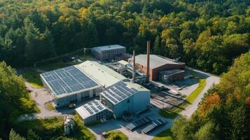 Aerial view of an industrial facility surrounded by trees, featuring solar panels photo