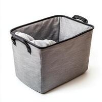 A gray fabric storage basket with handles and a soft blanket inside photo